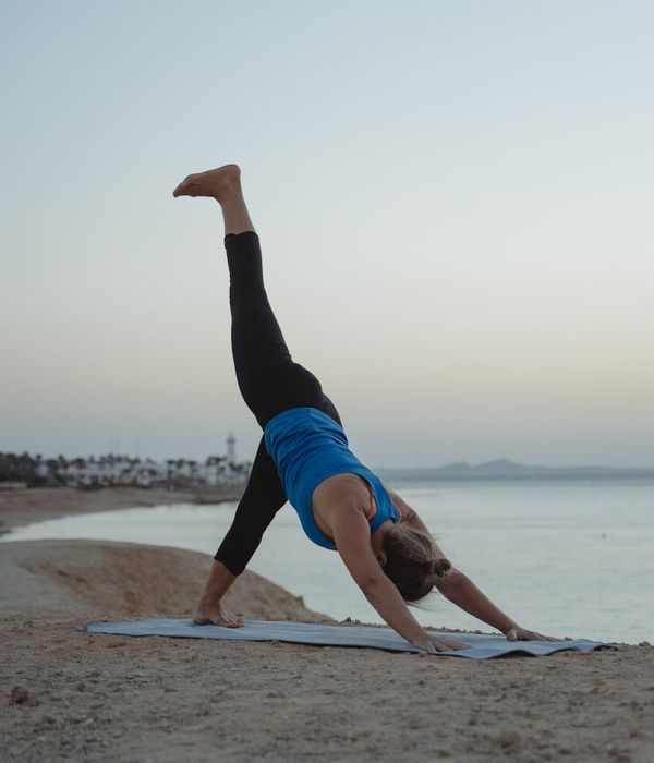 Woman in a peaceful yoga pose against a dark, calm background.